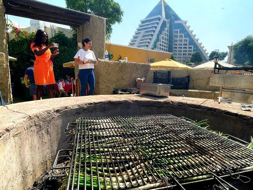Cientos de calçots se hacen a la leña en la enorme parrilla dispuesta para la ocasión por el Seville's en su terraza. (EL CORREO)