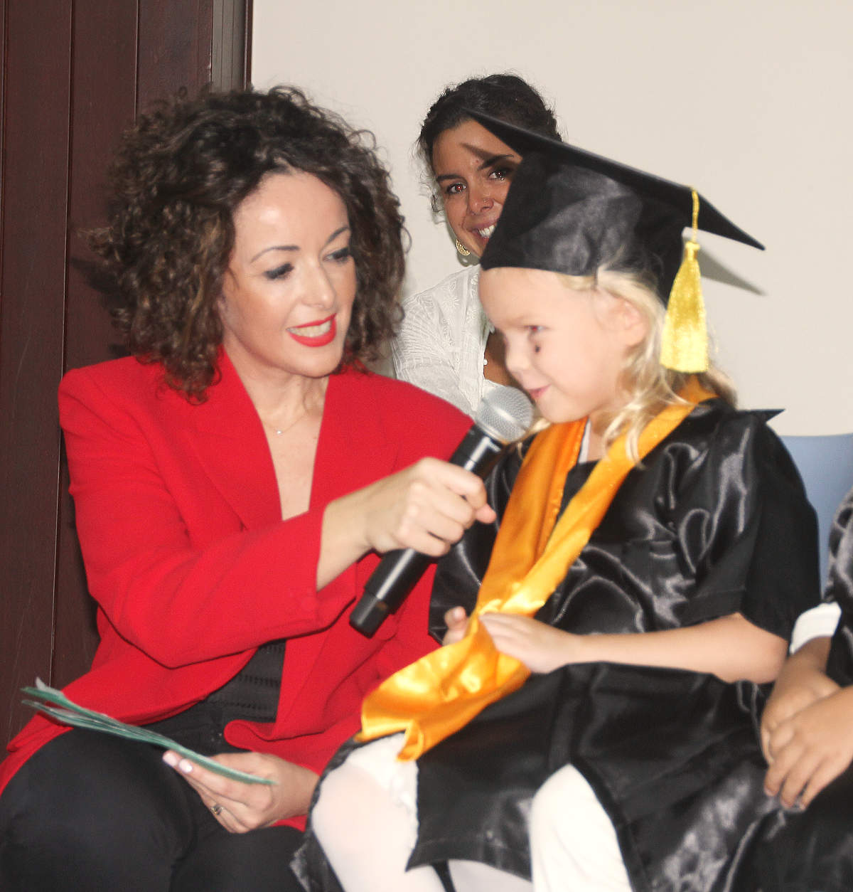 Verónica Montoro, conductora del acto de graduación, habla sobre el escenario con una de las protagonistas. (EL CORREO)