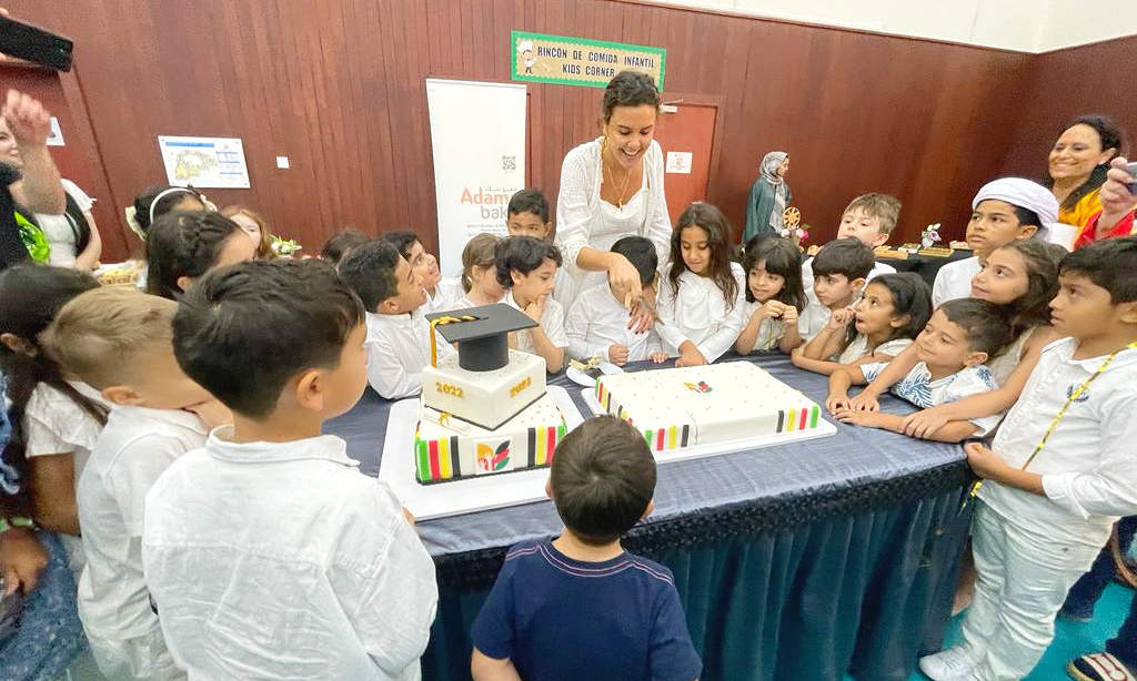 Miss Gabi corta la tarta junto a sus expectantes alumnos. (EL CORREO)