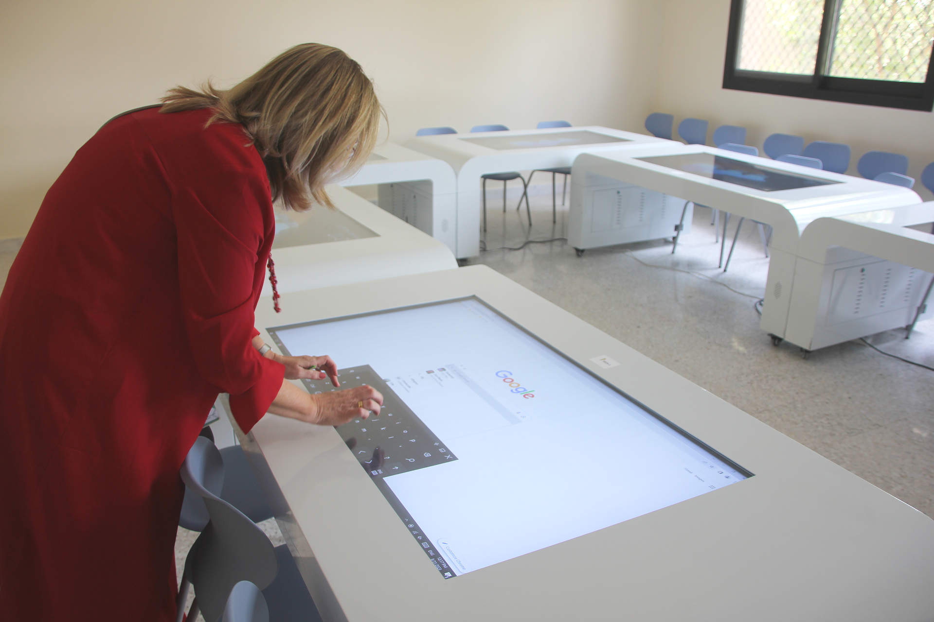 La directora de The Spanish School of Abu Dhabi navega por una de las enormes tabletas que presiden las mesas en una de las aulas de informática. (EL CORREO)