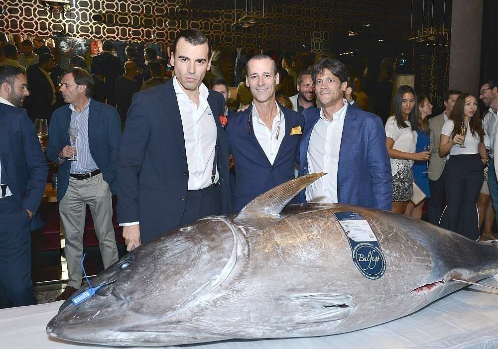 Jaime Castañeda -izquierda-, Fernando y Pedro de León posan junto al atún de 180 kilos en la jornada de inaguración de 99 Sushi Bar en Abu Dhabi. (Manaf K. Abbas)