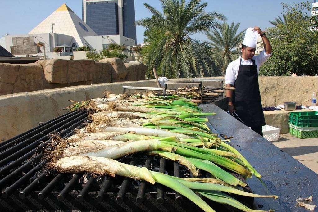 Los calçots, sobre las parrillas en la terraza del Seville's en Dubai. (EL CORREO)