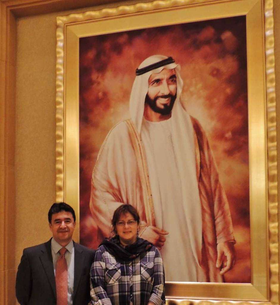 Dixon Acosta y Patricia Mogollón, autores de la biografía en español, junto al retrato del Jeque en Abu Dhabi. (Cedida)