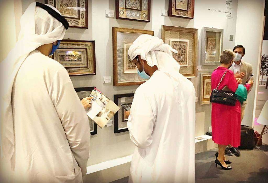 Emiratíes se interesan por los guadamecíes expuestos por el artista cordobés José Carlos Villarejo en Dubai. (EL CORREO)