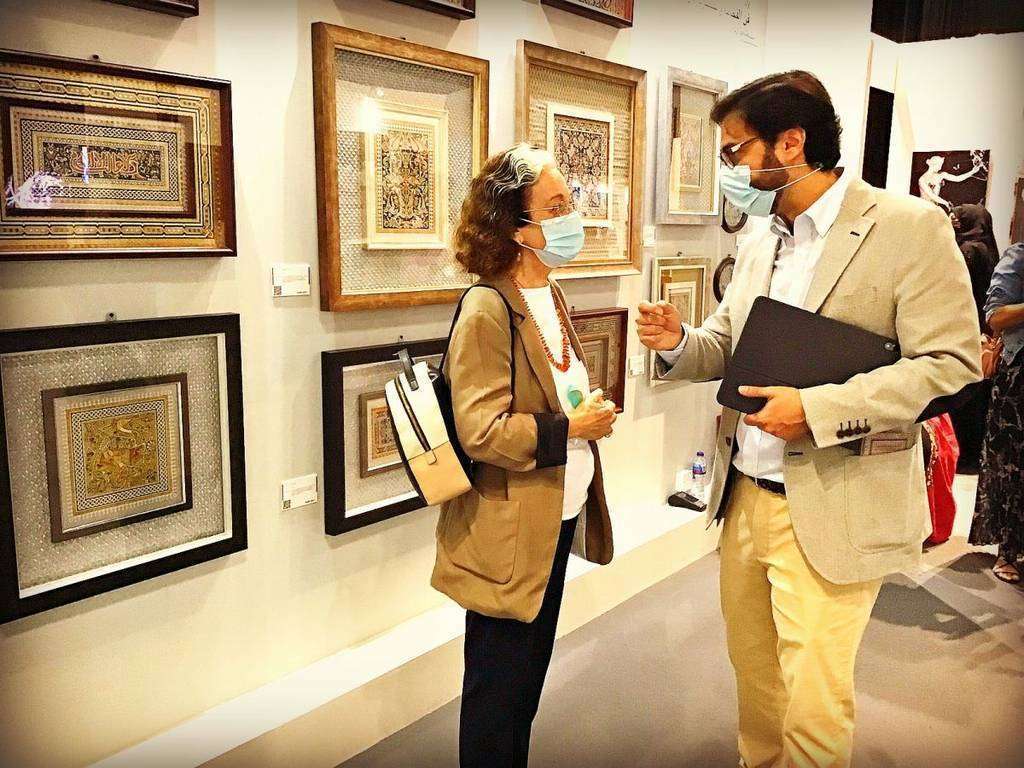 Jose Carlos Villarejo habla con la antropóloga española Inocenta Sánchez ante las obras que expone en Dubai. (EL CORREO)