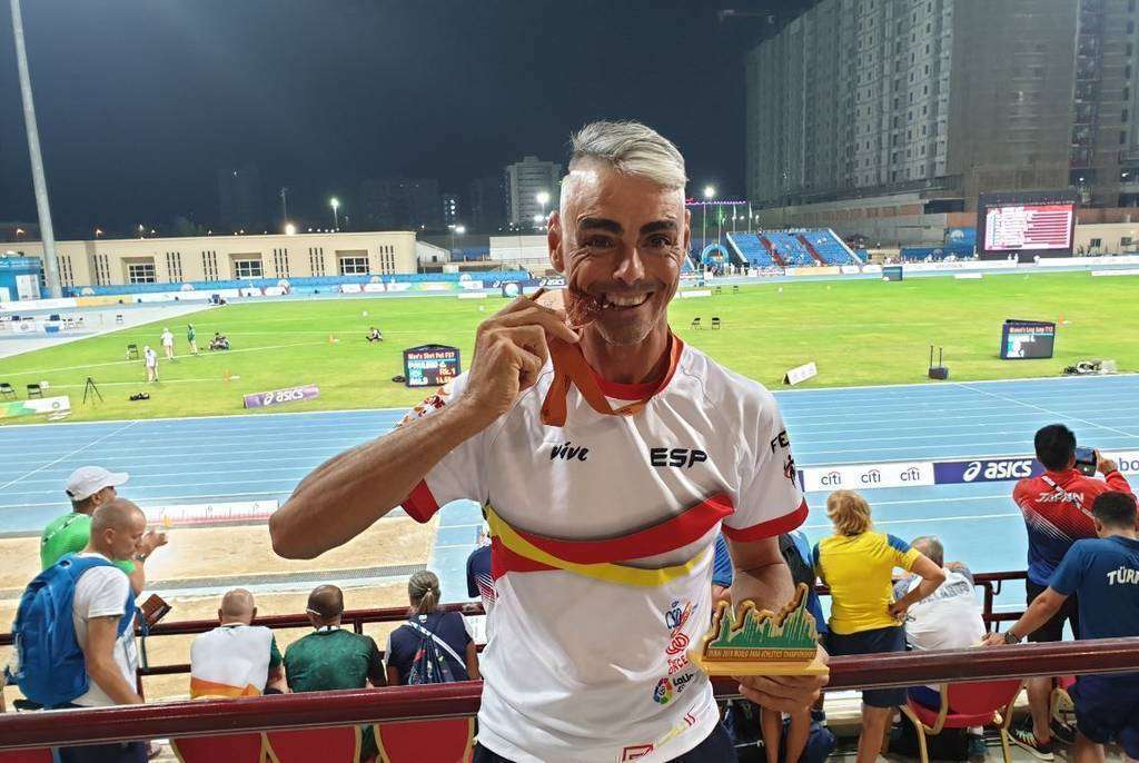 José Pámpano muerde la medalla de bronce que ha logrado en Dubai. (@paralimpicos)