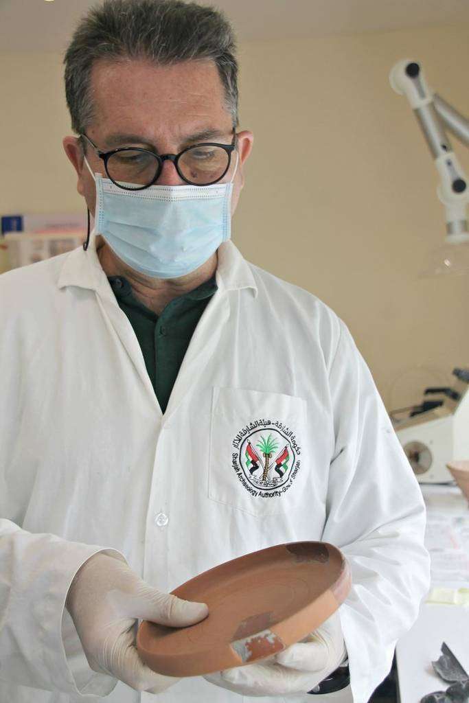 Miguel Ángel Núñez muestra una de las piezas restauradas en el laboratorio arqueológico que dirige en el emirato de Sharjah. (María Pirén Enciso / EL CORREO)