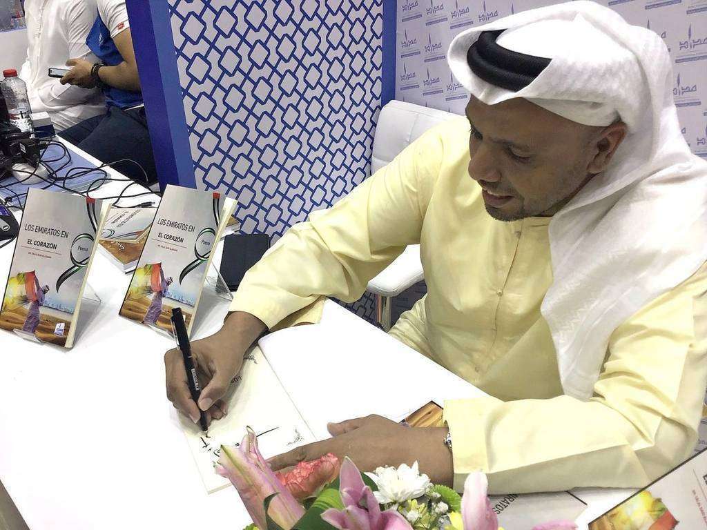 El poeta emiratí Talal Said Aljunaibi firma ejemplares en primorosa caligrafía árabe de su obra en español 'Los Emiratos en el corazón' durante la 38 edición de la Feria Internacional del Libro de Sharjah. (EL CORREO) El poeta emiratí Talal Said Aljunaibi firma ejemplares en primorosa caligrafía árabe de su obra en español 'Los Emiratos en el corazón' durante la 38 edición de la Feria Internacional del Libro de Sharjah. (EL CORREO)