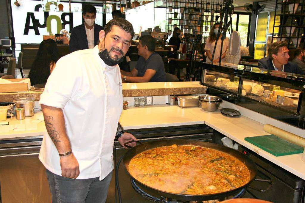 El chef Aleix Font, del restaurante Seville's, ante la espectacular paella que cocinó durante el evento. (EL CORREO)