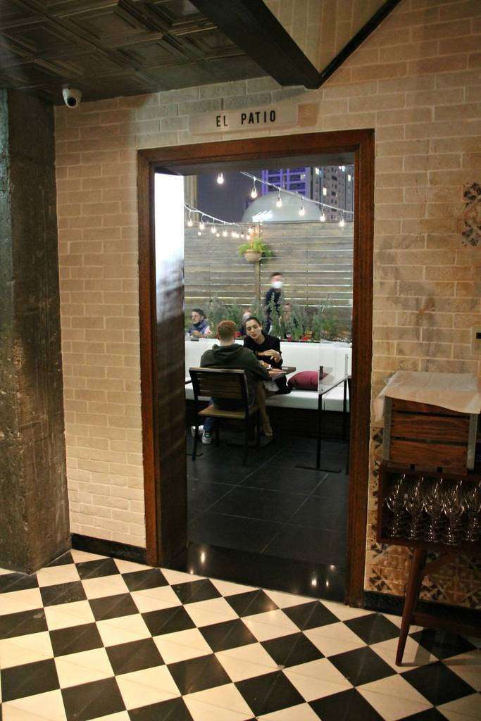 Una solería tradicional muy flamenca en blanco y negro nos lleva hasta la puerta de El Patio en la taberna 'Lola'. (EL CORREO)