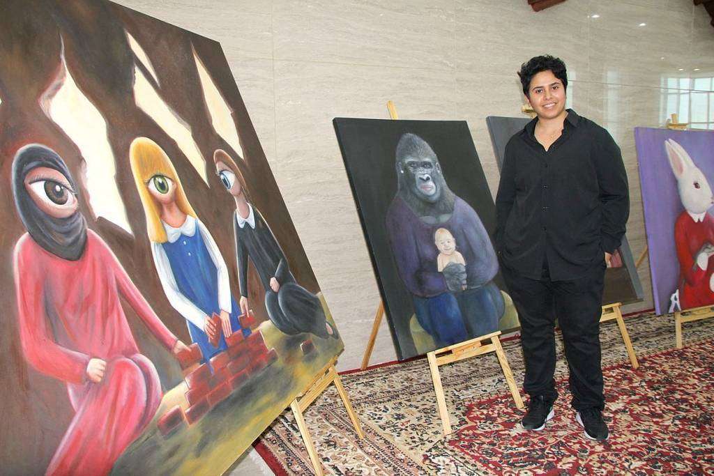 La pintora saudita Reem Alsuby posa junto a sus obras expuestas. (EL CORREO)